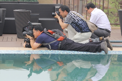 摄影师在泳池边找寻最好的角度